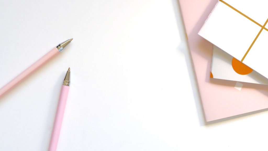 Flatlay photo of pens and notebooks